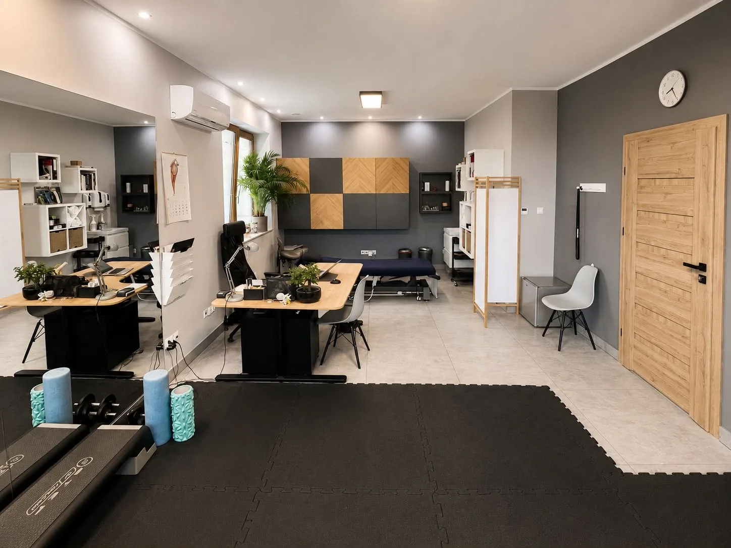 Sala z matą do ćwiczeń i biurkami do konsultacji